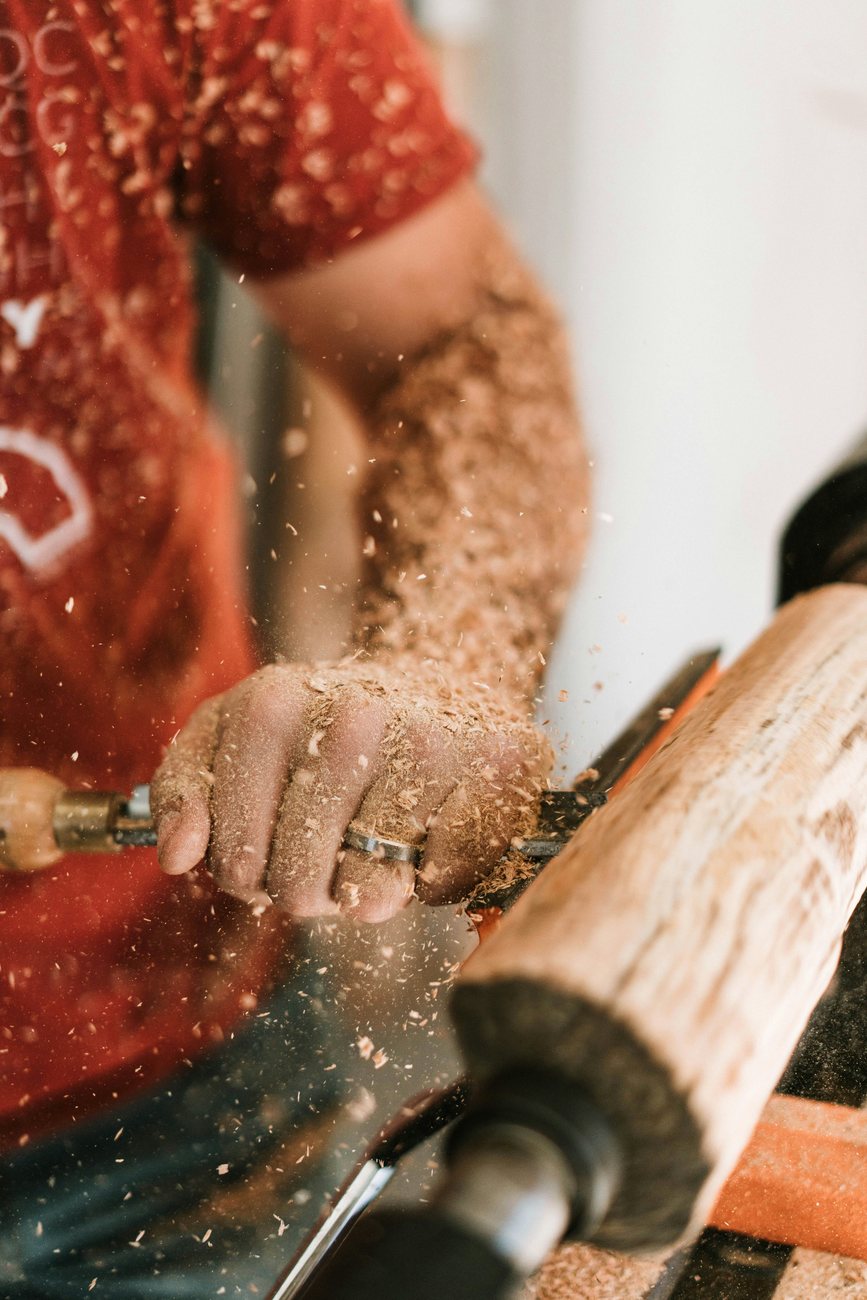 Carlos torneando una pieza de madera en el taller